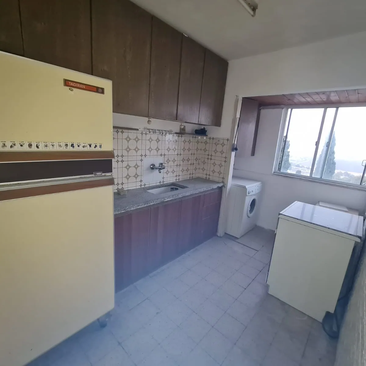 מטבח ישן עם ארונות חומים לפני השיפוץ